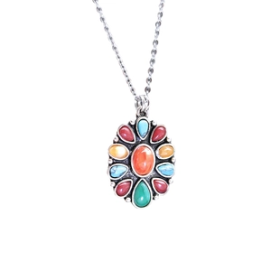 Bohemian silver necklace featuring a floral-shaped pendant with red and turquoise stones
