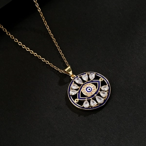 Collana placcata oro con ciondolo occhio del diavolo e zirconi su sfondo nero puro