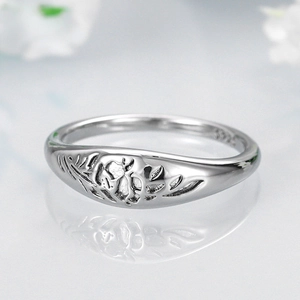 Macro shot of silver S925 ring showing intricate floral engravings and polished inner band