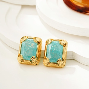 Macro detail of 18K gold vintage earrings featuring rectangular ice blue gemstones
