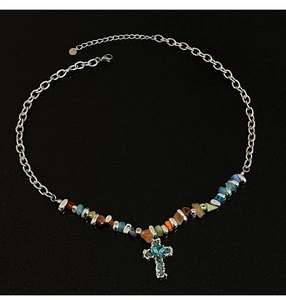 Close-up of silver chain necklace with colorful crushed stones and blue crystal cross