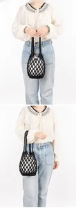 Close-up of black woven crochet handbag featuring a white drawstring canvas inner bag