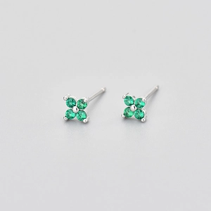 Detail macro view showing green cubic zirconia stones on silver clover stud earrings