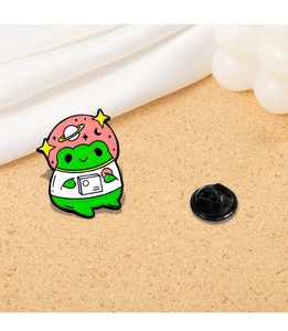 Detailed close-up of a green frog astronaut enamel pin with space helmet and rubber back