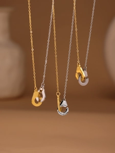 Vue détaillée des pendentifs menottes bicolores sur chaînes en acier inoxydable