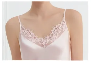Detailed close-up of V-neckline with delicate lace trim on pink silk sleepwear