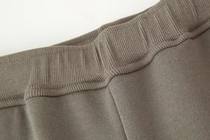 Detailed macro view of ribbed knit waistband and fleece fabric on casual trousers