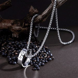 Silver stainless steel stickman engraved ring and box chain necklace on dark pebbles