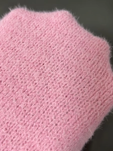 Nahaufnahme der weichen rosa Strickstruktur mit flauschigen Plüschfasern