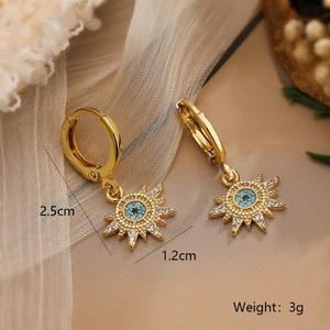 Detail view of 18K gold plated sun earrings with turquoise bead and clear crystal accents