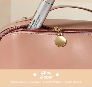 Detail of pink PU makeup bag with smooth chrome alloy zipper and gold round puller