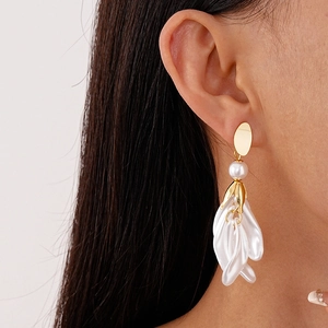 Boucles d'oreilles vintage avec pétales, perles blanches et finition dorée sur modèle