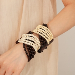 Detail of bohemian multilayered coconut shell wood bead elastic bracelet worn on wrist