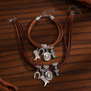 Detail of Western jewelry set with horseshoe and cowboy hat charms on wooden background