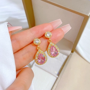 Close-up of pink teardrop crystal earrings with micro-inlaid diamonds in a jewelry box