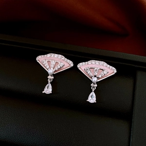 Vue détaillée des boucles d'oreilles éventail avec émail, zircone et perle sur un coffret