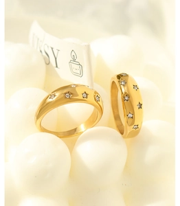 Detailed view of two 18K gold plated stainless steel rings with star-set zircon crystals
