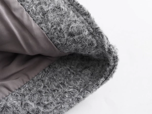 Vue détaillée du tissu en peau de mouton synthétique grise et de la doublure intérieure