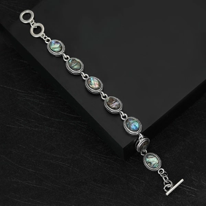 Close-up of vintage silver bracelet with oval abalone shell inlay and T-bar toggle clasp