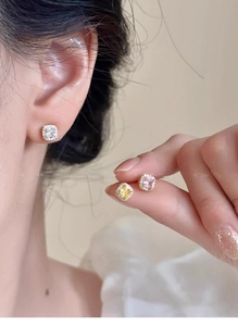 Detail view of square zircon earrings in white, yellow, and pink gold plated finishes