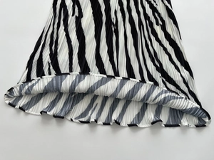 Detailed view of black and white zebra print on pleated fabric with rolled hem finish