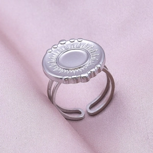 Macro shot of silver 304 stainless steel ring with radial sunburst disc and open band