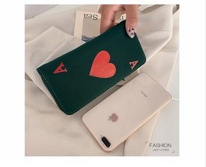 Close-up of Ace of Hearts design on dark green canvas long wallet with gold zipper