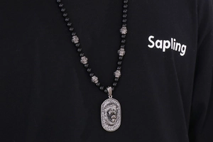 Detail shot of vintage beaded titanium steel necklace with a silver lion head pendant