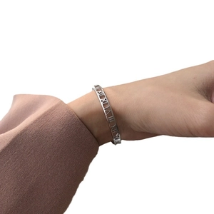 Elegant S925 sterling silver open bangle with Roman numerals cut-out on a female wrist