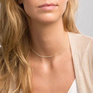 Close-up of minimalist silver thin chain necklace worn by a model for professional display