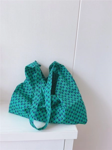 Detailed close-up of green and blue geometric pattern on large canvas tote bag