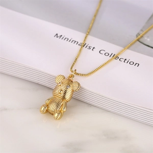 Collier avec pendentif ours doré et zircone cubique sur un fond blanc épuré