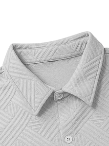 Gros plan d'une chemise gris clair montrant le tissu jacquard géométrique et les boutons