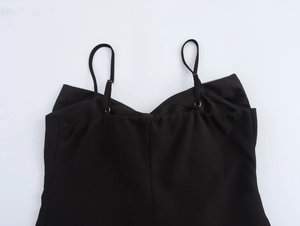 Détail des bretelles de caraco noir avec boucles en métal et tissu lisse