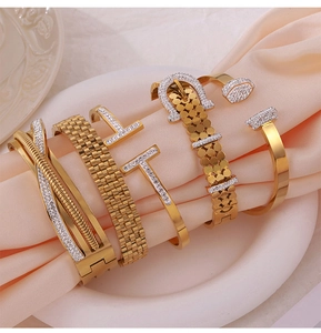 Macro shot of gold plated geometric bangles with pavé zircon settings on silk fabric