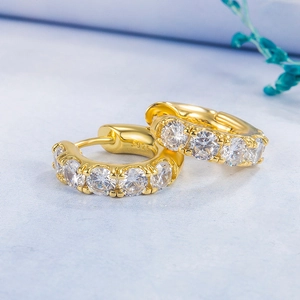 Macro shot of S925 silver gold-plated emerald earring with hallmark and zircon detail