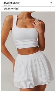Detail of white yoga set featuring square neck tank top and high-waist pleated tennis skirt