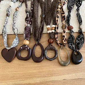 Bohemian fabric-wrapped long necklace with wooden beads and mixed geometric heart pendants