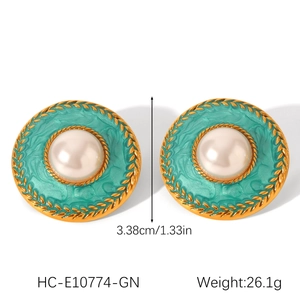 Detail of vintage mint green enamel earrings with pearl inlay and golden frame