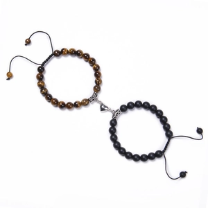 Close-up of tiger eye and matte black magnetic heart bracelets for couples