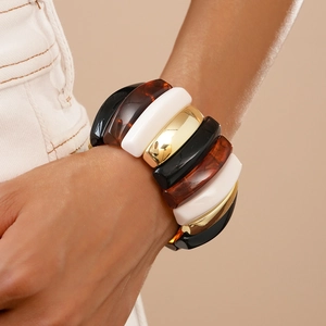 Detail view of bold acrylic resin bracelet with amber texture and gold metal blocks