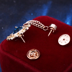 Detail of vintage gold collar chain brooch with blue gemstones and metal chains on velvet