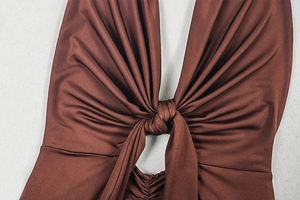 Close-up of brown bodycon dress featuring central knot and pleated texture details