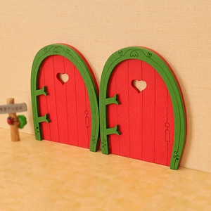 Red and green miniature wooden dollhouse doors with heart cutouts for Christmas decor