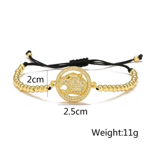 Detail showing gold leopard head with green crystal eyes on a beaded drawstring bracelet