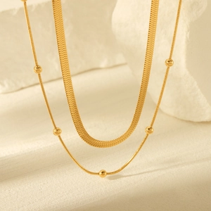Elegant gold double-layered stainless steel necklace featuring snake and bead chain