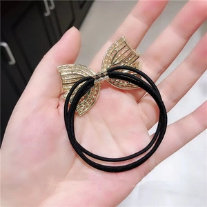 Elegant gold butterfly hair tie with black elastic band for stylish ponytail styles
