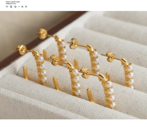 Detailed view of three pairs of baroque pearl C-shape earrings in 18k gold-plated steel