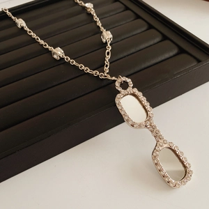 Macro view of lorgnette glasses pendant with rhinestones on a black velvet tray