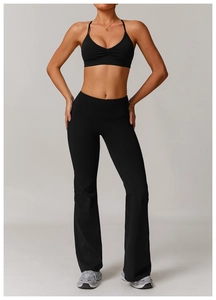 Detail of V-neck ruched sports bra and flared yoga pants set in high-stretch black fabric